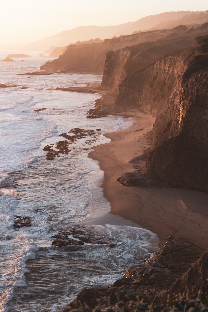 Golden light over a rugged coastline with rolling surf